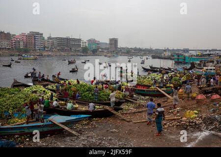 Arbeiter sind damit beschäftigt, saisonale Früchte von Booten in Wiseghat in Old Dhaka zu entlasten. Bangladesch Stockfoto