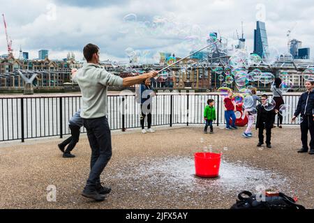 Straßenkünstler am Südufer bläst Blasen für Kinder. London, England, Großbritannien, Europa Stockfoto