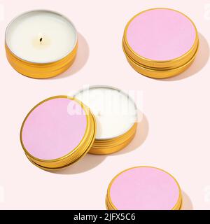 Aroma Sojawachskerzen in einem Metallglas. Modernes farbenfrohes Muster mit Duftkerzen in einer Metallkeuche. Rosa Kerzen für gemütliche Atmosphäre und Aromatherapie. Stockfoto