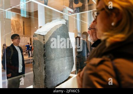Besucher sehen sich den Rosseta-Stein an. Der Rosetta-Stein ist eine Granodioritstele, die mit drei Versionen eines in Memphis, Ägypten, erlassenen Dekrets beschriftet ist. Der Stockfoto