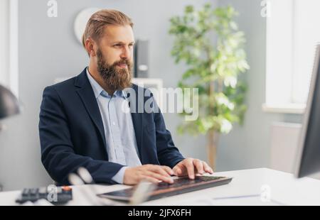 Erfolgreicher Geschäftsmann, der am pc arbeitet Stockfoto