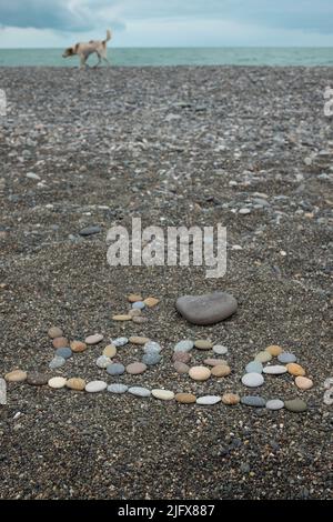 Ich liebe Yoga Text aus Steinen am Strand. Draufsicht Stockfoto
