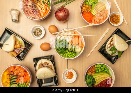 Hawaiianische Poke-Schüssel mit rotem Thunfisch, edamamen Bohnen, gekochten Eiern, frischer Gurke, mariniertem norwegischen Lachs, Afrikanische Mango, Salz, sortiert Stockfoto