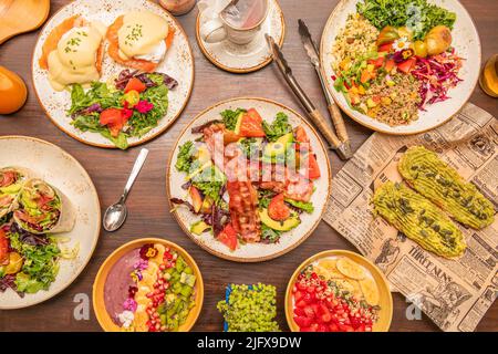 Set von gesunden Frühstück und Brunch-Gerichte mit Eiern benedict, acai-Schüssel, gebratenen Speck, Avocado mit Kürbiskernen und Gemüse Stockfoto