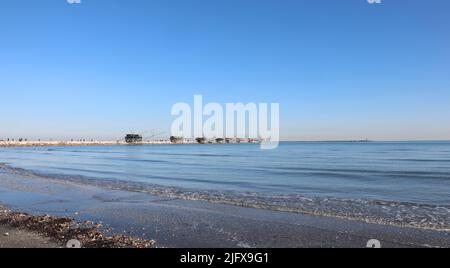 Ufer des Strandes bei Ebbe und die Holzhäuser Trabucchi in italienischer Sprache auf den Felsen Stockfoto