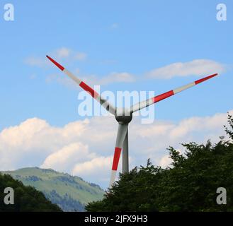 Große rote und weiße Windmesser für die Erzeugung von sauberem Strom und die Nutzung der Kraft des Windes Stockfoto