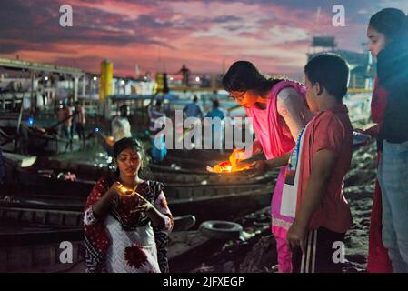 Dhaka, Bangladesch. 05.. Juli 2022. Hindu-Anhänger versammeln sich am Fluss Buriganga, um ihre Lampen zu schweben, kurz nachdem sie ihnen Bipodhnashini puja angeboten haben. Jedes Jahr feiern hinduistische Anhänger das religiöse Fest von Bipodhtarani Puja und beten zu Bipodtaraini Devi für ihr Wohlergehen. Kredit: SOPA Images Limited/Alamy Live Nachrichten Stockfoto