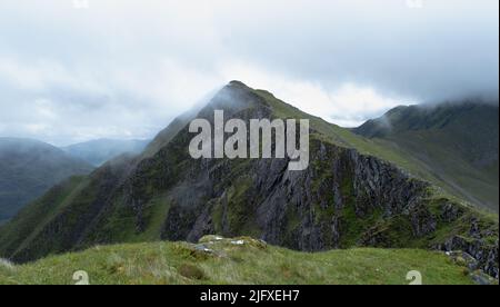 Spazieren Sie entlang der fünf Schwestern von Kintail Ridge, während die Wolken auf die Gipfel in den schottischen Highlands, Schottland, herabsteigen Stockfoto