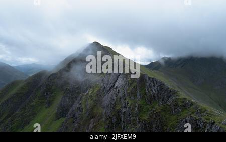 Spazieren Sie entlang der fünf Schwestern von Kintail Ridge, während die Wolken auf die Gipfel in den schottischen Highlands, Schottland, herabsteigen Stockfoto