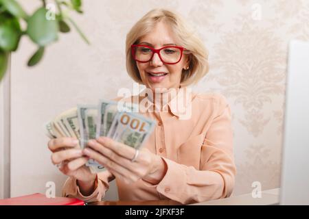 Eine Frau mit Banknoten in den Händen zählt Dollars Geld Bargeld. Stockfoto