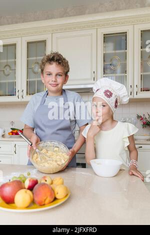 Kinder in der Küche bereiten einen Apfelkuchen zu. Stockfoto