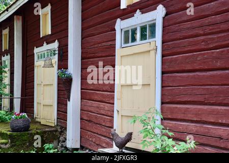 Altes Blockhaus mit gelben Türen in Uukuniemi in Ostfinnland im Juni 2022 Stockfoto