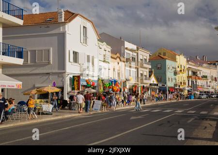 Touristen, die entlang der Handelsstraße am Nazare-Strand, Portugal, Europa, spazieren. Stockfoto