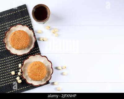 Mondkuchen auf weißem Hintergrund mit Tee. Concept Moon Cake auf dem Mid Autumn Festival oder dem chinesischen Neujahr. Mooncake beliebt als Kue Bulan. Serviert mit Chines Stockfoto