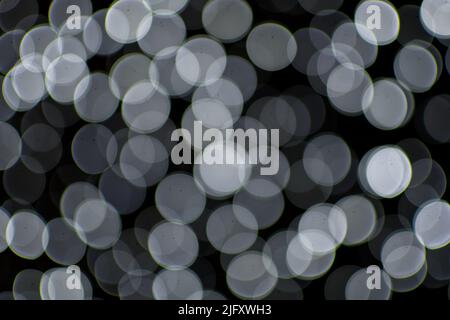 Hintergrundbild mit schwarz-weißen Bokeh-Lichtern. Stockfoto