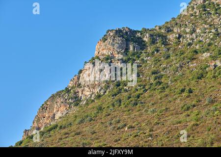 Landschaftsansicht der Berge in Hout Bay in Kapstadt, Südafrika während Sommerferien und Urlaub. Malerische Hügel, Landschaft mit frischer grüner Flora Stockfoto