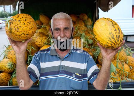 Antalya , TÜRKEI - 30. Juni 2022 : Ein türkischer Gemüsehändler, der Melone auf dem Freitagsmarkt in Antalya verkauft. Stockfoto