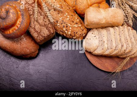 Draufsicht auf geschnittenes Vollkornbrot auf dunklem ruktischem Holzhintergrund. Stockfoto