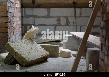 Auf dem Boden liegen Reste der Mineralwolldämmplatte Stockfoto