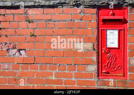 Prestatyn, Großbritannien. Juni 22, 2022. Ein roter Briefkasten, der in einer Ziegelwand montiert ist Stockfoto