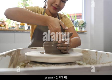 Konzentrierte asiatische Frau Herstellung Keramik Topf auf Töpfer Rad. Aktivität, Handwerk, Hobbys Konzept Stockfoto