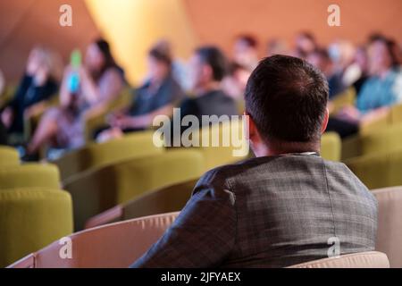 Anonymer männlicher Manager, der im Sessel des Forums sitzt Stockfoto