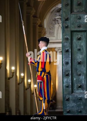 Vatikanstadt, Vatikan, März 2022. Nahaufnahme eines päpstlichen Schweizers in traditioneller Uniform, der das eiserne Tor bewacht. Stockfoto