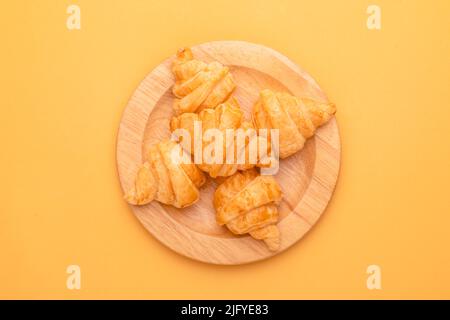 Draufsicht Mini Croissant in Holzschale auf gelbem Hintergrund. Food-Konzept mit Kopierraum Stockfoto