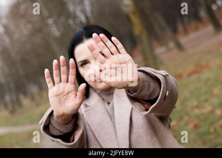 Frau streckt ihre Hände mit offenen Handflächen als Stoppschild Stockfoto