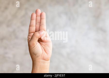 Nahaufnahme mit drei-Finger-Symbol auf grauem Hintergrund mit Kopierfläche Stockfoto