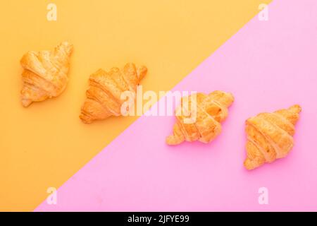 Draufsicht Mini Croissant in Holzschale auf gelbem Hintergrund. Food-Konzept mit Kopierraum Stockfoto