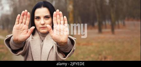 Frau streckt ihre Hände mit offenen Handflächen als Stoppschild Stockfoto