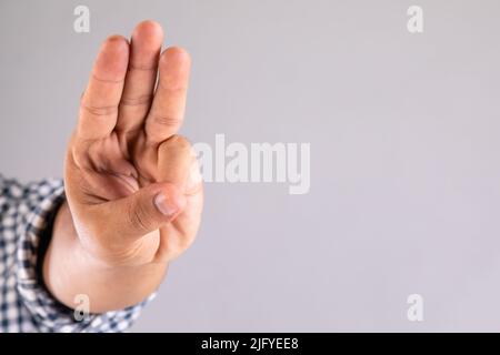 Nahaufnahme mit drei-Finger-Symbol auf grauem Hintergrund mit Kopierfläche Stockfoto
