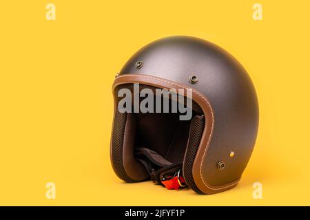 Nahaufnahme des neuen grauen Vintage-Helms. Studioaufnahme isoliert auf gelbem Hintergrund Stockfoto