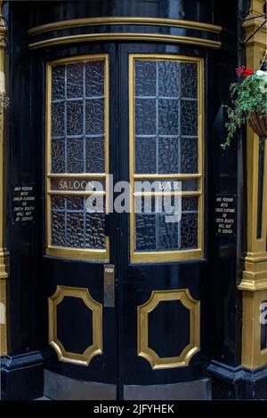 Außenaufnahme der gebogenen Glastür aus dem Cockpit Pub in St. Andrew's Hill in der City of London. Stockfoto