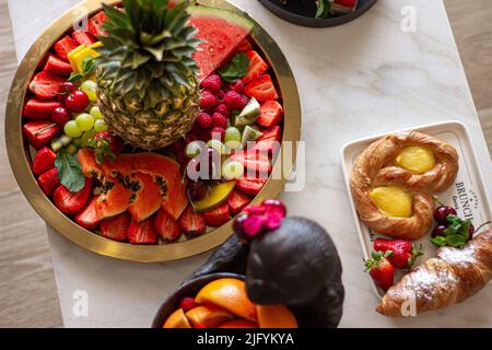 Eine Draufsicht auf Wassermelone, Erdbeeren, Kirschen, Trauben, Himbeeren, Trauben, Ananas und Kiwi, neben anderen Süßigkeiten Stockfoto