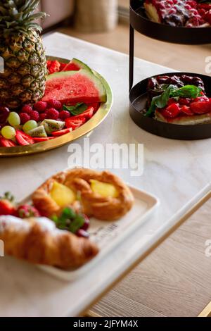 Eine vertikale Aufnahme von Wassermelone, Erdbeeren, Trauben, Himbeeren, Ananas, Und Kiwi, neben anderen Süßigkeiten Stockfoto