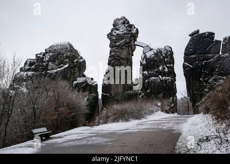 An einem bewölkten Wintertag ist die Felsformation Externsteine schneebedeckt, Teutoburger Wald, Deutschland Stockfoto