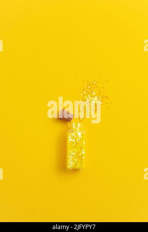 Gelbes Glitzerrohr auf gelbem Hintergrund. Party-Konzept, Kopierraum. Stockfoto