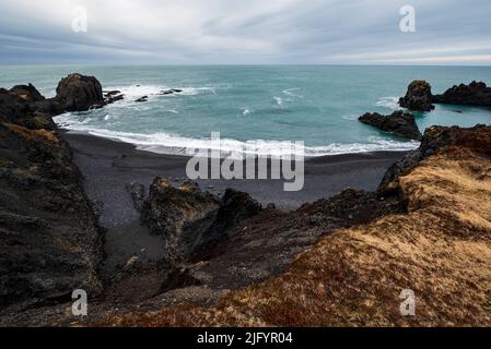 Erhöhter Blick auf die Bucht von Dritvík, Snæfellsnes, Island. Panoramalandschaft mit wunderschönem schwarzen Lavastrand und verschiedenen Basaltsteinformationen. Stockfoto