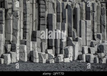 Die vertikalen Basaltsäulen am Reynisfjara, dem berühmten schwarzen Strand Islands, nahe Vík í Mýrdal, bilden ein perfektes geometrisches Hintergrundmuster Stockfoto