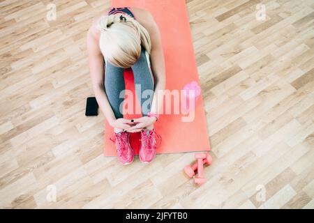 Müde Mädchen sitzt in der Turnhalle nach dem Training Stockfoto