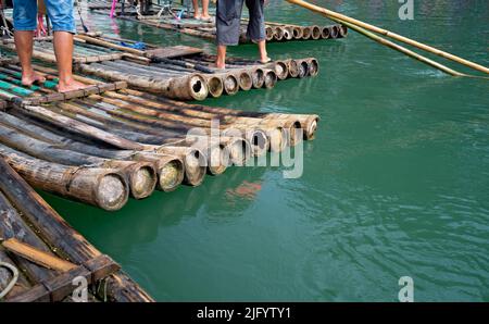 Nahaufnahme von Bambusflößen für Touristen, die von Führern auf dem malerischen und wunderschönen Fluss Yulong in Yangshuo, China, gesteuert werden Stockfoto