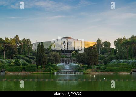 EUR See in Rom, Italien. Sonnenuntergang im Park mit dem Palazzo dello Sport und bunten Springbrunnen Stockfoto