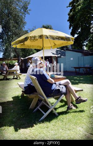 Pärchen, die unter dem Sonnenschirm sitzen Stockfoto