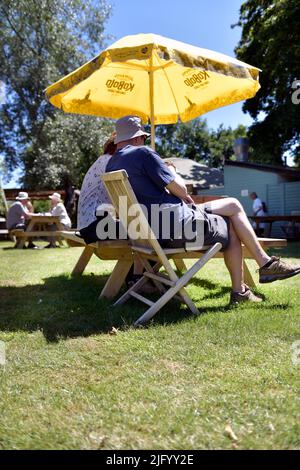 Ein Paar sitzt unter dem Sonnenschirm Stockfoto