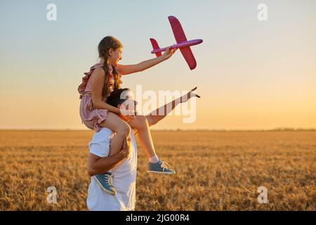 Nettes Mädchen, das auf der Schulter des Vaters reitet Stockfoto