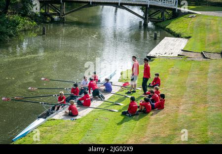 Junge junge Schüler von Lehrern der Magdalen College School Oxford, die am Ufer des Flusses Cherwell Ruderskulpen-Bootsunterricht erhalten haben Stockfoto