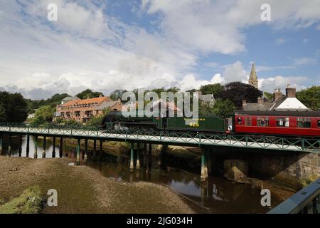 Dampfzug (SR S15-Lokomotive), der rote Personenwagen über den Fluss Esk, North Yorkshire, Großbritannien, zieht Stockfoto