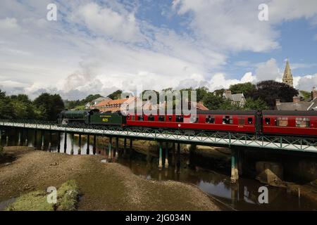 Dampfzug (SR S15-Lokomotive), der rote Personenwagen über den Fluss Esk, North Yorkshire, Großbritannien, zieht Stockfoto